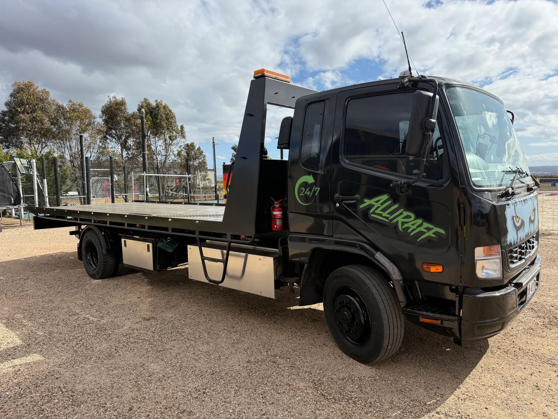 Alliraf Transport tilt tray truck hauling a vehicle across regional Victoria
